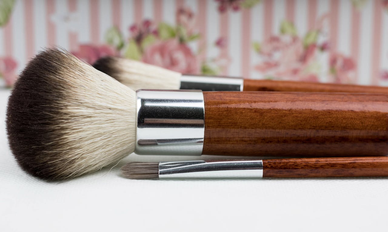 A detailed close-up of makeup brushes with a floral background, ideal for beauty themes.