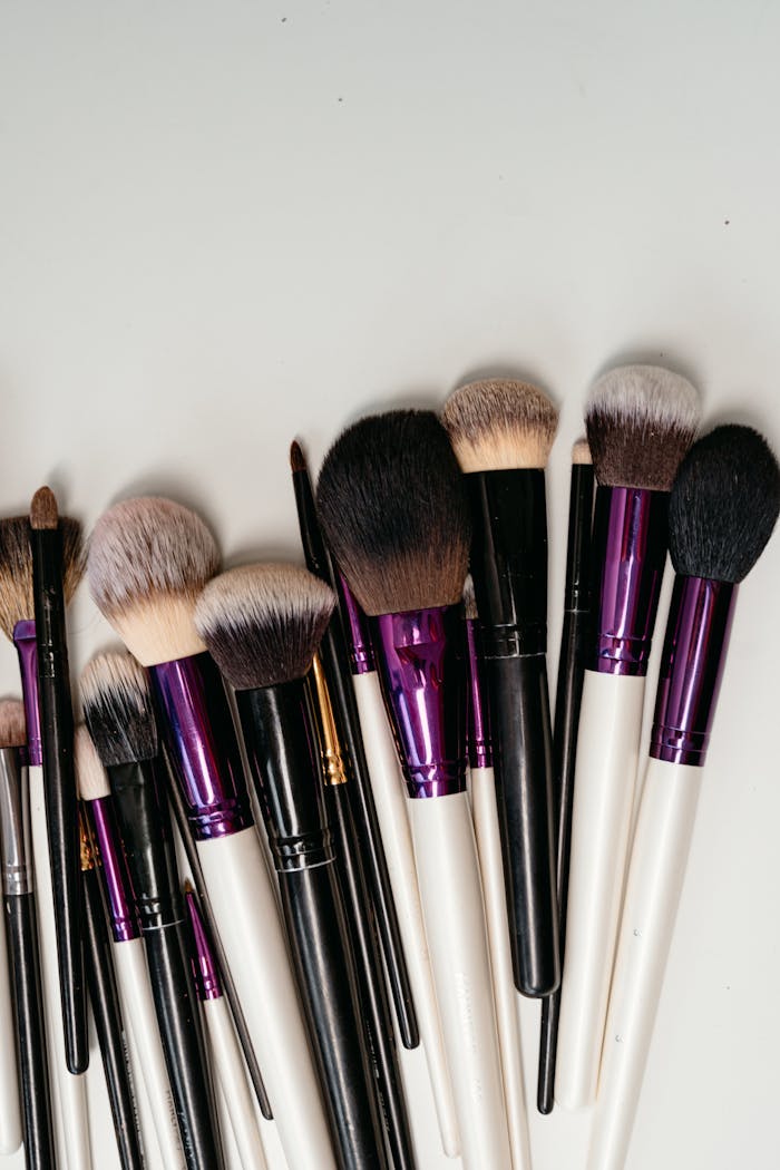 Assorted makeup brushes with black and white handles for cosmetics application.