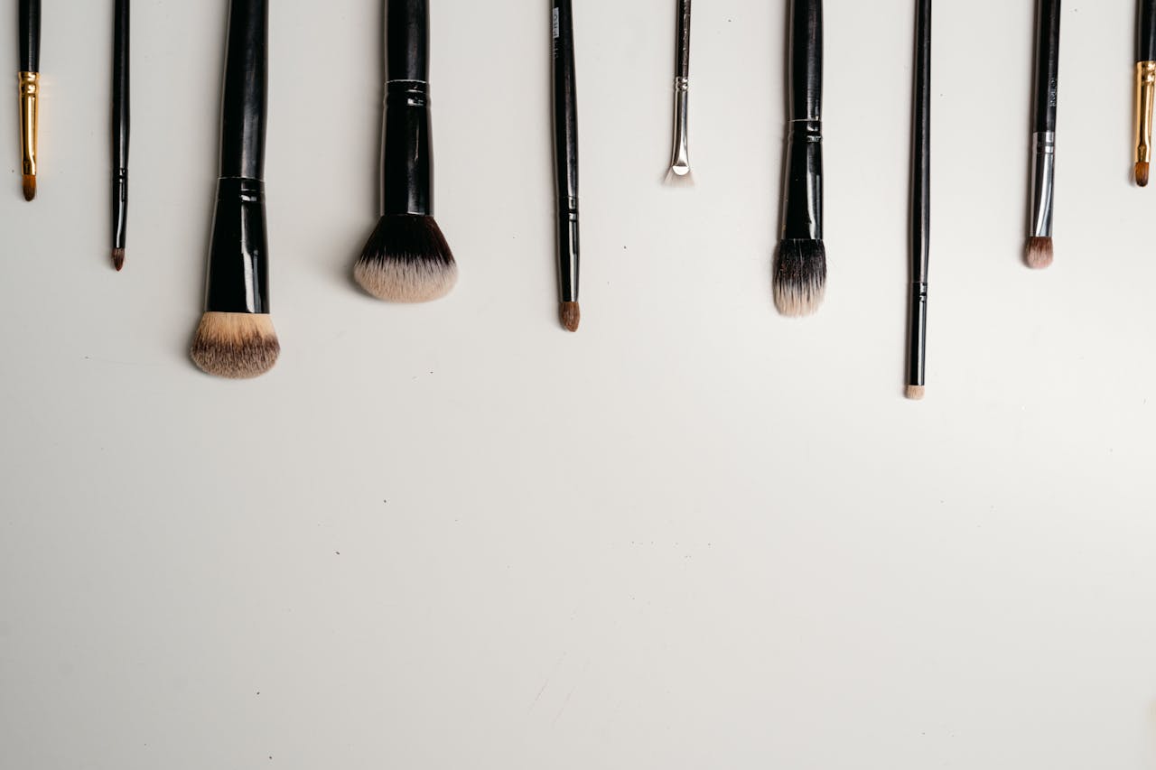 A flat lay of makeup brushes arranged on a white background, ideal for beauty themes.