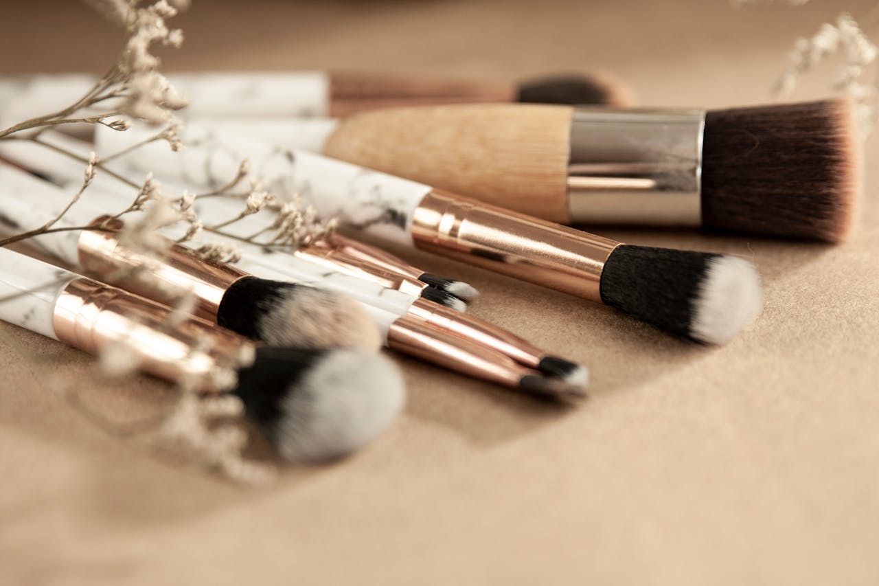Collection of elegant makeup brushes on beige background, perfect for beauty enthusiasts.